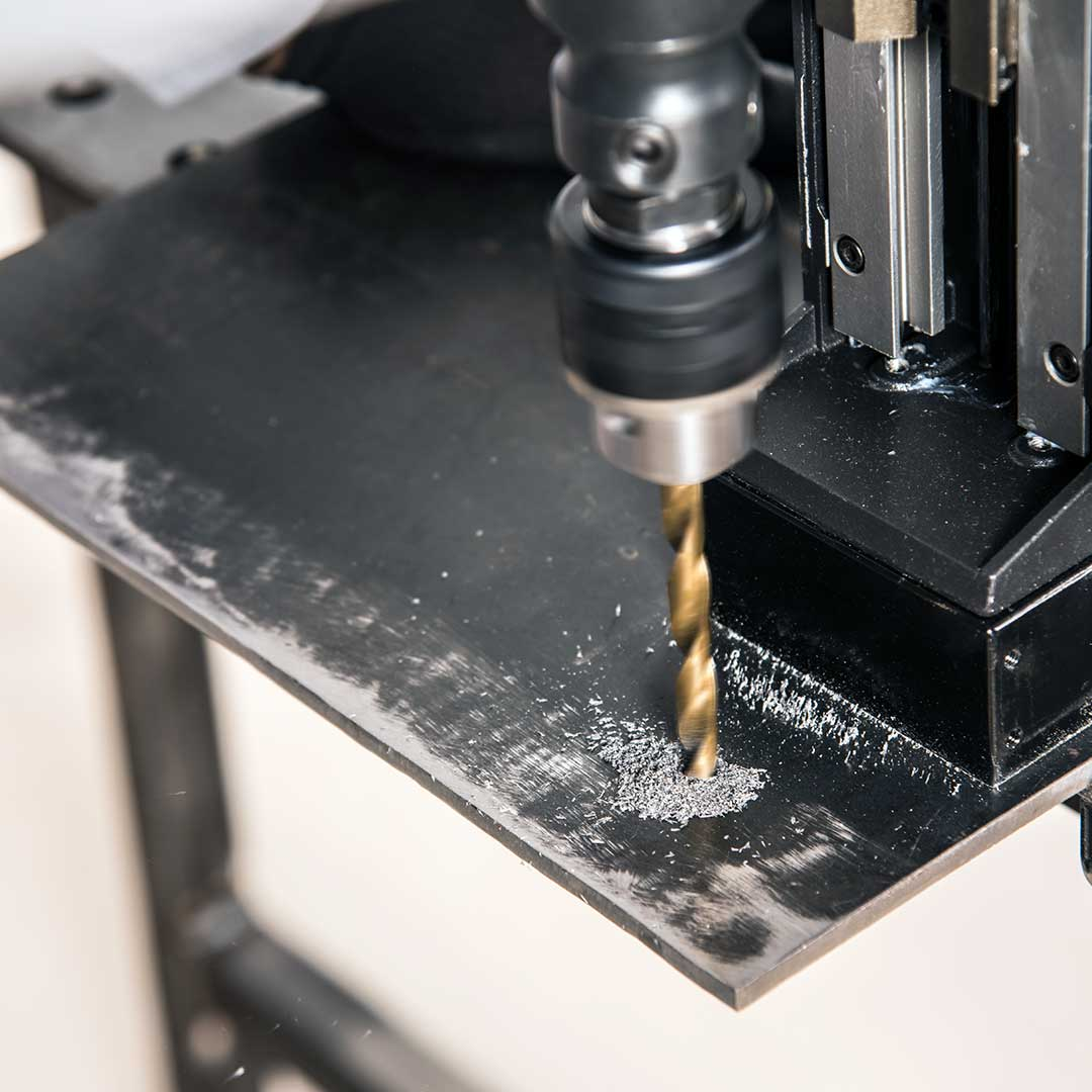 Evolution Power Tools 1-1/8 in. Magnetic Drill With Carry Case S28MAG performing precision twist drilling on a steel plate using the included drill chuck for versatile hole-making applications.