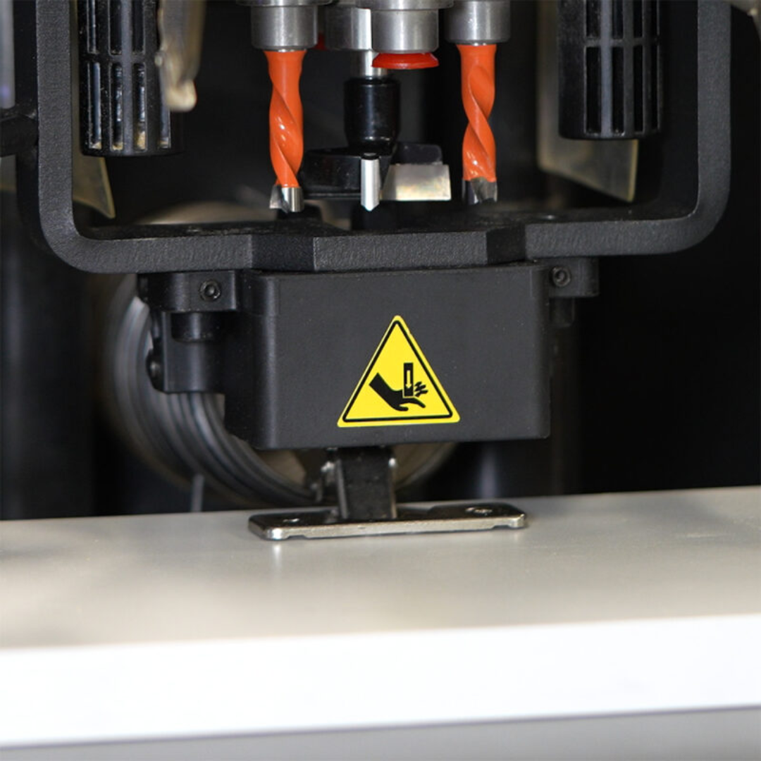 Lower interior section of the Maksiwa HBM-1000 showing safety warning labels and internal processing units