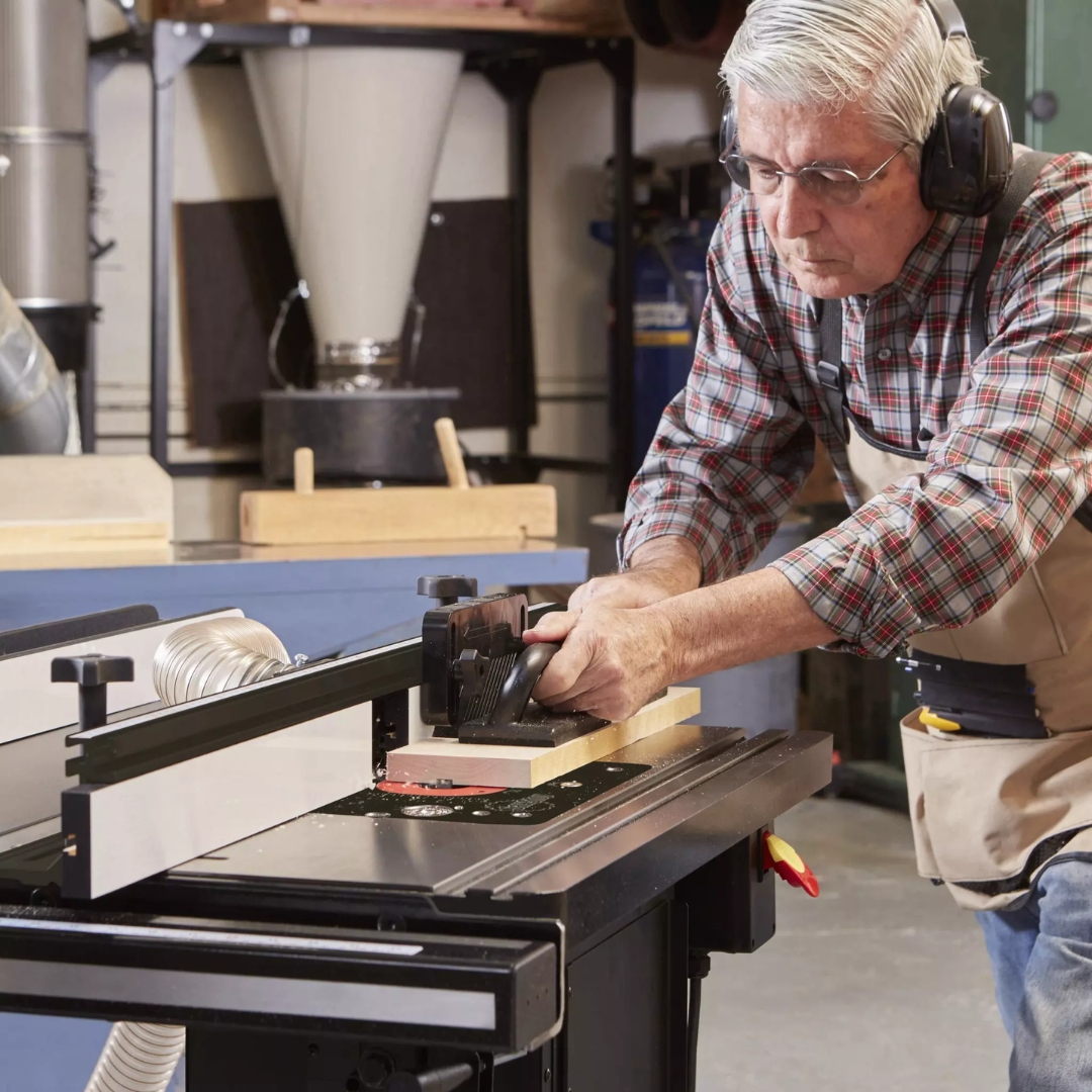 User adjusting the SawStop Compact Table Saw controls for precise cutting depth and optimized woodworking performance.