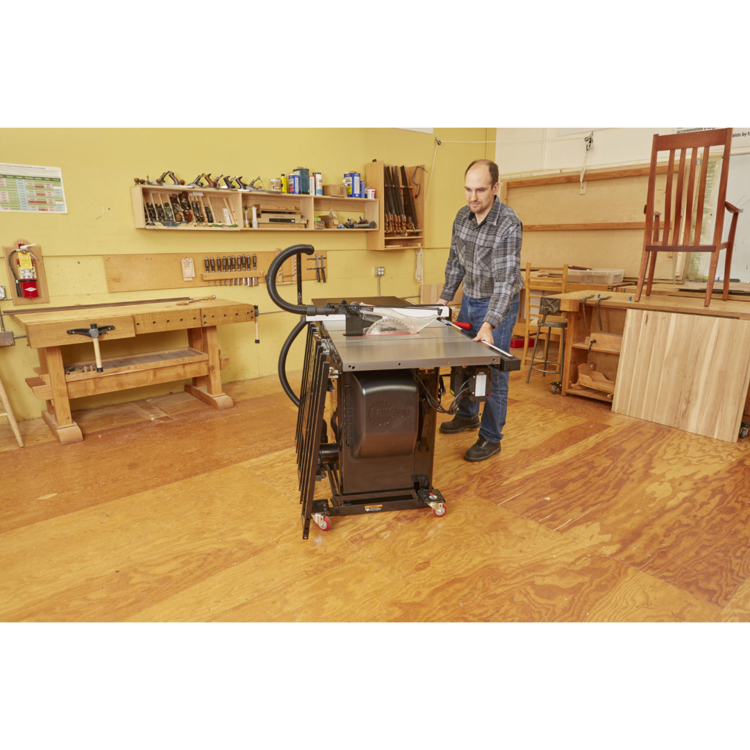 Workshop demonstration of the SawStop Industrial Mobile Base For PCS MB-PCS-IND supporting a cabinet table saw, providing mobility, workspace flexibility, and heavy-duty performance for industrial applications.