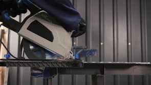 Evolution Power Tools Metal Cutting Circular Saw S210CCS cutting steel material in a fabrication workshop, demonstrating portable cold-cutting performance for industrial metalworking applications.
