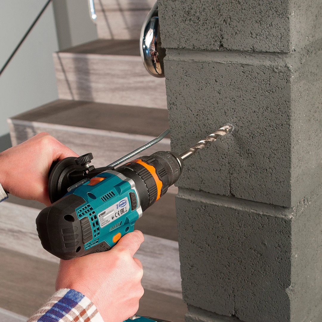 Close-up of Virutex Cordless Impact Drill/Screwdriver ATB80P performing heavy-duty drilling into masonry surface