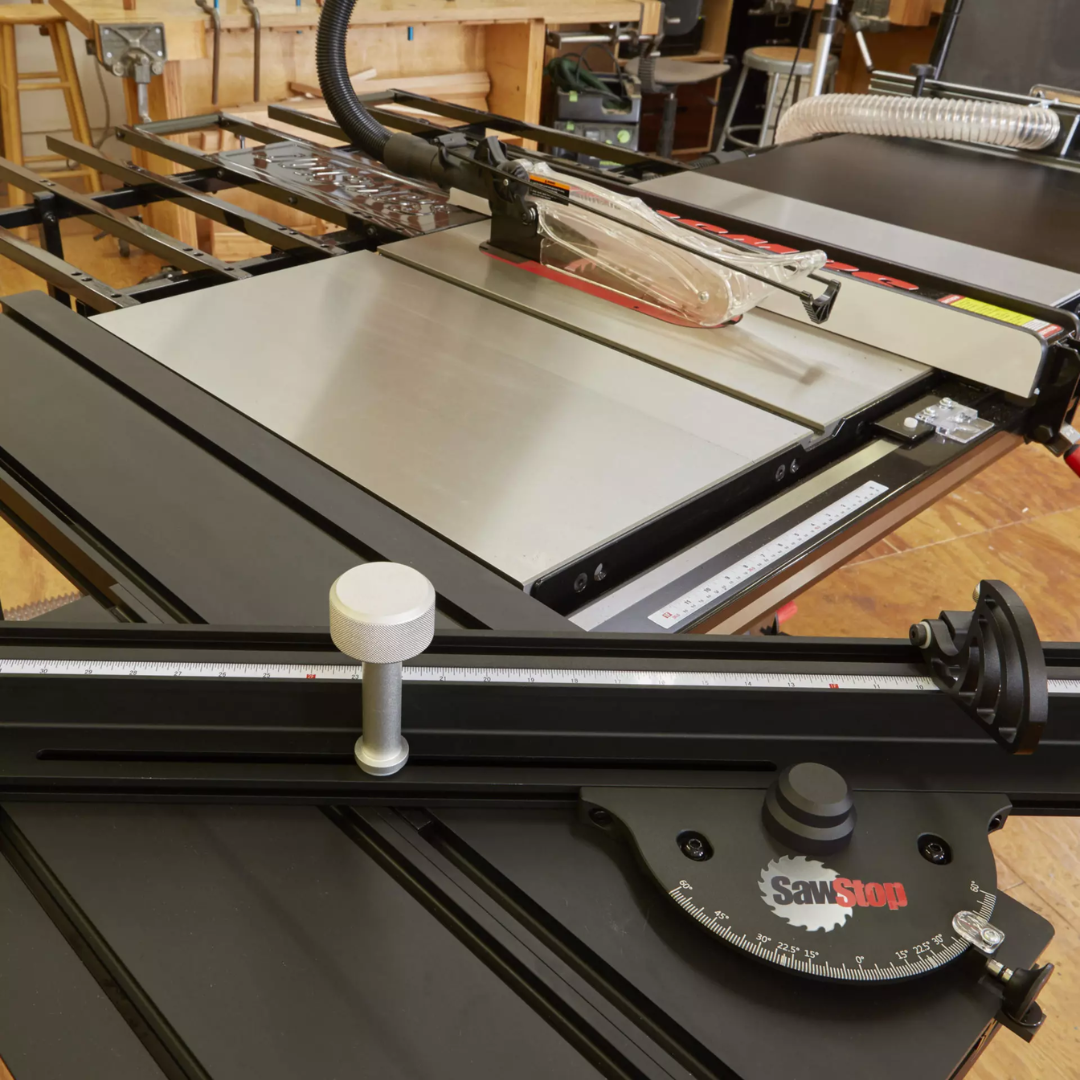 Craftsman operating the SawStop Compact Table Saw while cutting wood, showcasing safety technology and professional-grade accuracy.