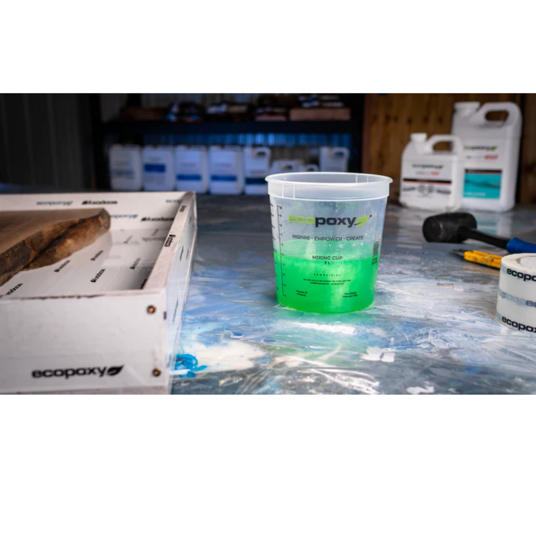 Ecopoxy Graduated Epoxy Mixing Cups in use with tinted resin mixture during epoxy preparation process.
