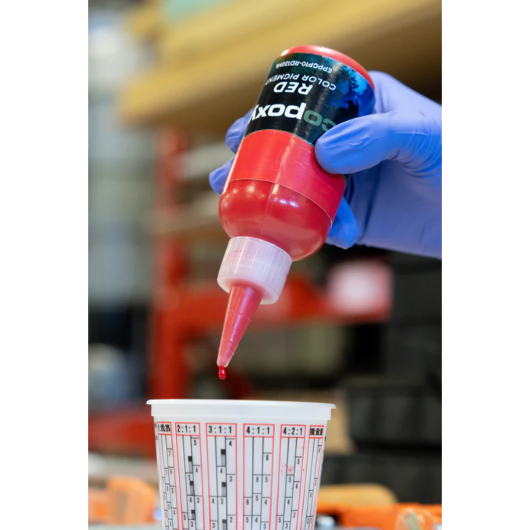 Ecopoxy Liquid Color Pigments being dispensed into a measuring cup for precise color control in epoxy applications.