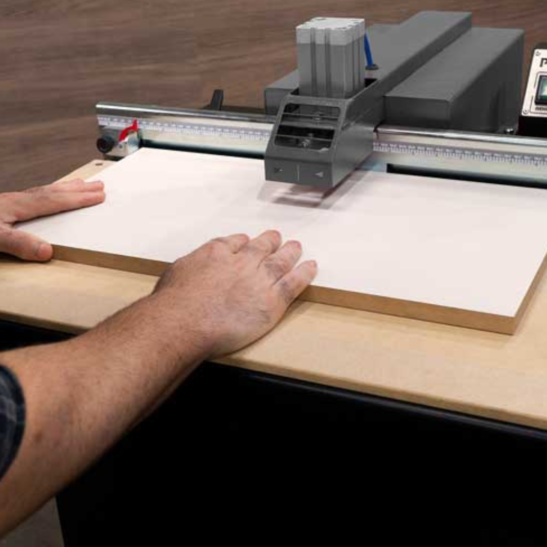 Operator carefully positioning board on Maksiwa PHM.30 Pocket Hole Machine