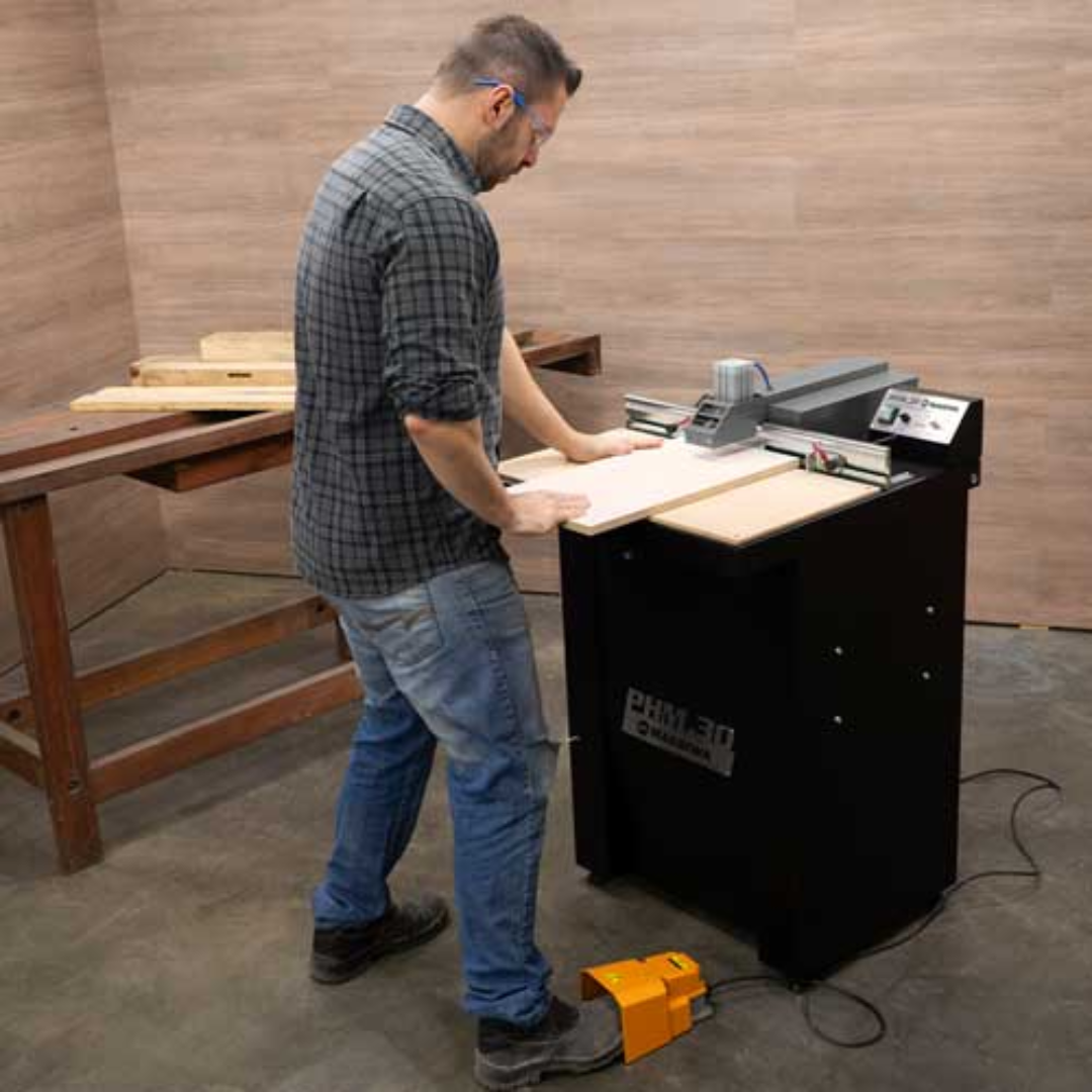 Operator using Maksiwa PHM.30 Pocket Hole Machine to drill pocket holes in wood panel