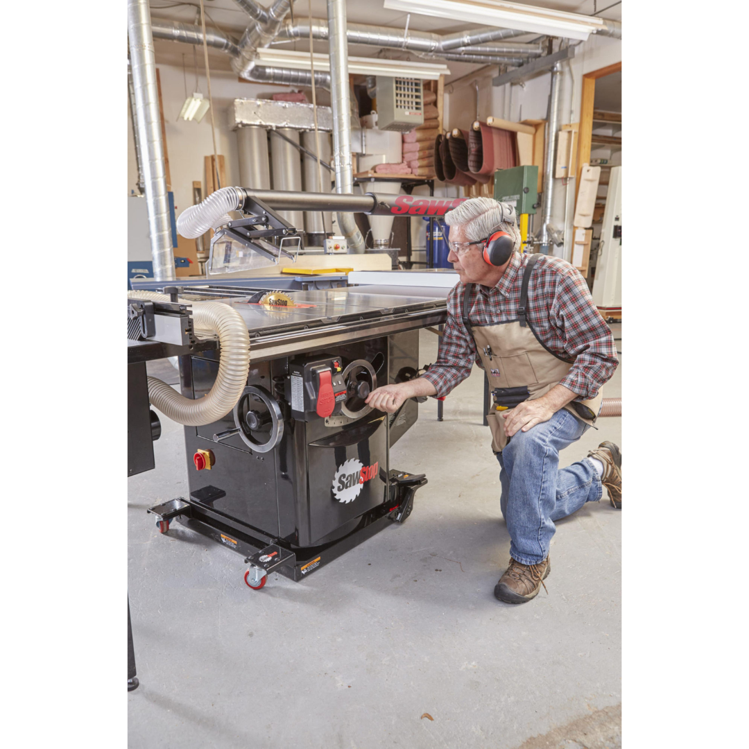 Operator using the SawStop Industrial Saw Mobile Base MB-IND-000 to reposition a heavy industrial cabinet saw, highlighting effortless mobility and hydraulic lift-assisted operation.