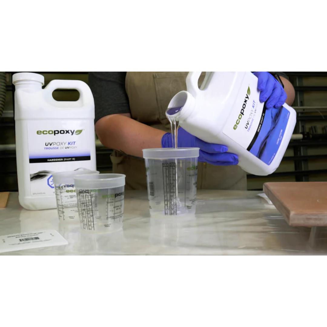Pouring liquid resin into Ecopoxy Graduated Epoxy Mixing Cups with visible graduated measurement markings.