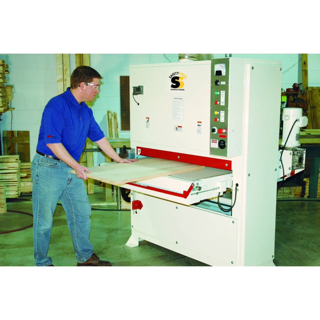 Safetyspeed 43″ Wide Belt Sander operator feeding material through conveyor for precision sanding