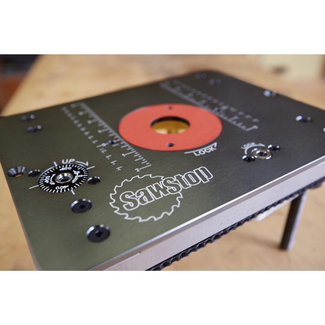SawStop Router Lift RT-LFT top plate surface with branding, insert ring, and control features designed for seamless integration into router table setups.