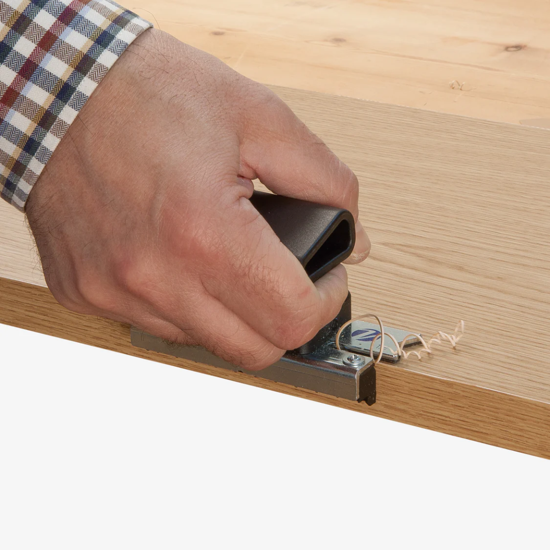 Virutex Scraper Edge Trimmer RP28 For Finishing 2800200 in use scraping edge banding to remove excess material and achieve a smooth finish.