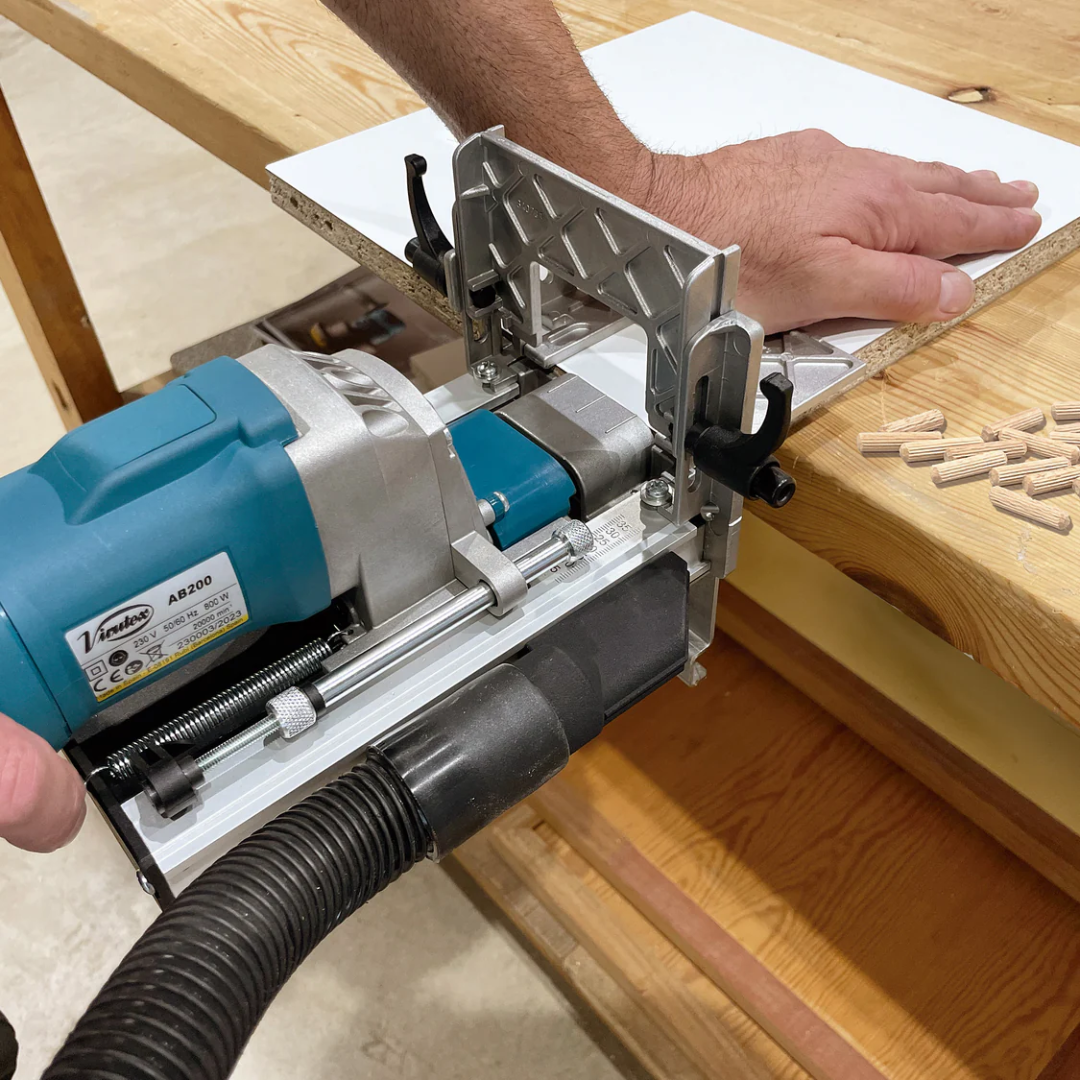 Virutex TWOO AB200 Corded Dowel Jointer (120V) 7900799 performing horizontal dowel drilling operation on workbench with guide fence for stability