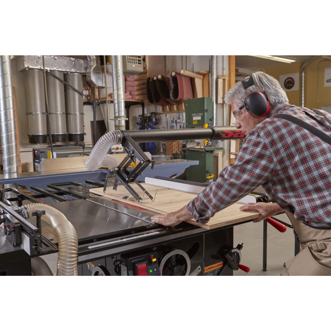 Woodworker operating the SawStop Industrial Cabinet Saw in a production shop environment, demonstrating industrial cutting power and accuracy.