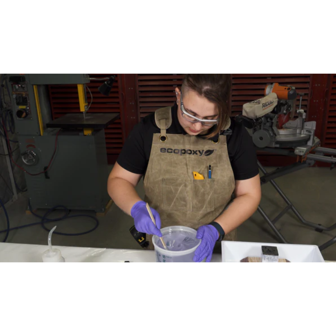Woodworker using tools while wearing the Ecopoxy Canvas Apron EPAPR10-CV for shop protection and convenience.