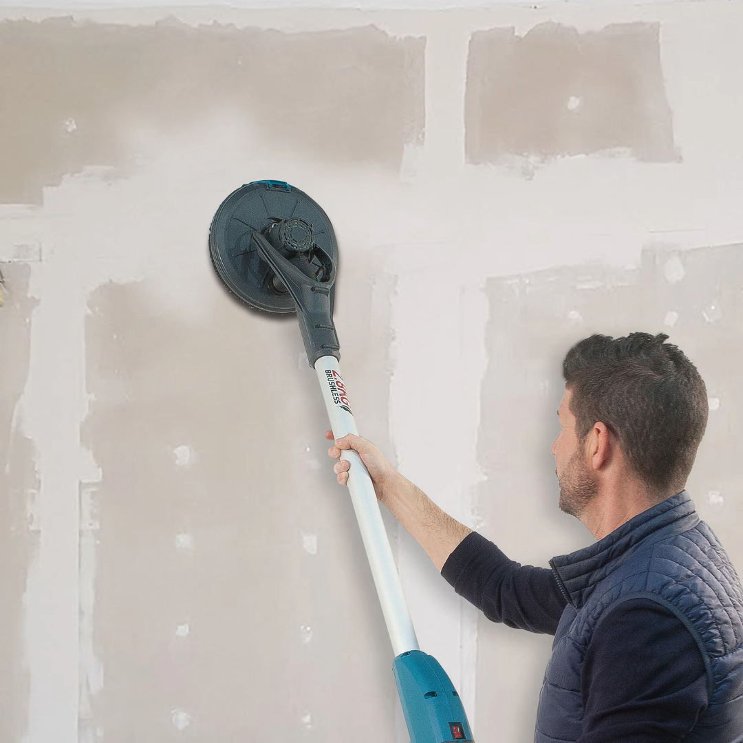 Worker using Virutex LPC197 Long Reach Drywall Sander (120V/230V) 9700200 to smooth drywall surface during finishing process